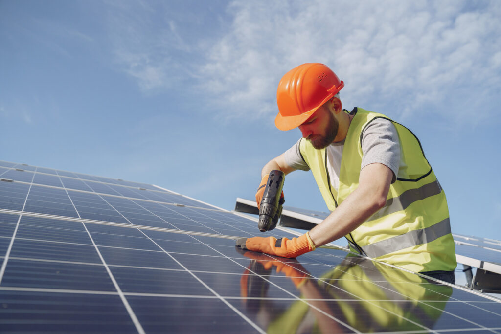 How Much Does Solar Cost After Incentives? 1 Man in a protective helmet. Installing stand-alone solar panel system after homeowners discovered the cost of solar