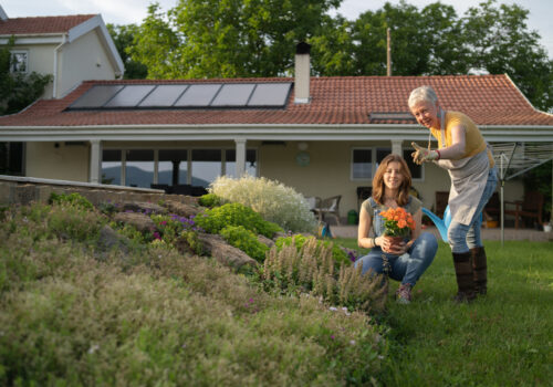 A woman and her granddaughter work in a garden after obtaining solar power. Solar cost using incentives helped prevent issues.