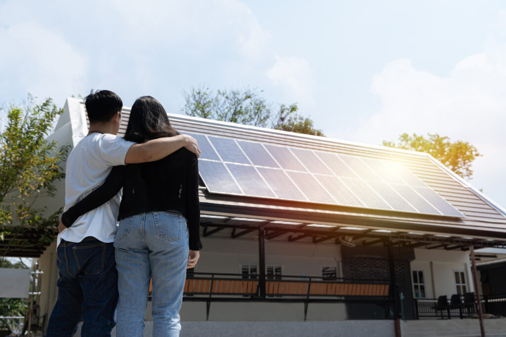 What Should You Know Before Hiring a Solar Company? 1 A couple stands looking at their roof after hiring a solar company to install solar panels on their home